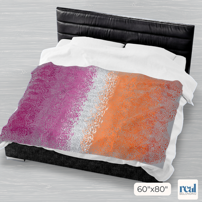Colorful abstract patterned comforter on a bed with a headboard.